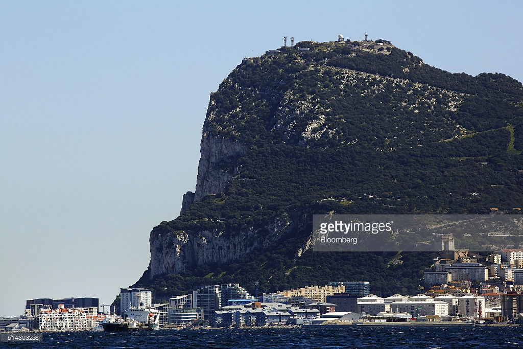 Commercial and residential buildings stand along the waterline at the base of the rock of Gibraltar in Gibraltar, U.K., on Sunday, March 6, 2016. Gibraltar is a the 300-year-old low-tax British territory on the southern tip of Spain. Photographer: Luke MacGregor/Bloomberg